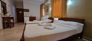 尼欧波洛伊马诺拉斯公寓式酒店的一间卧室配有两张带白色枕头的床