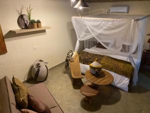 ToubakoutaToubacouta Lodges的一间卧室配有一张带天蓬和桌子的床