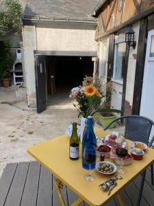 Vernou-sur-BrenneGîte cosy entre Tours et Amboise的一张带食物和一瓶葡萄酒的黄色桌子