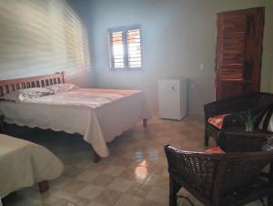 伊塔雷马Pousada Villa Marini的卧室配有床、椅子和窗户。