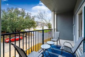 圣安东尼奥Spacious New Condo! Near FtSam Houston*Alamo*Pearl的阳台配有桌椅和汽车。