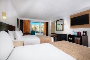 坎昆克里斯塔尔坎昆的酒店客房设有两张床和一台平面电视。