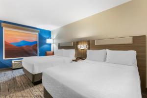 贝尔格莱德贝尔格莱德博兹曼地区智选假日酒店的酒店客房设有两张床,墙上挂有绘画作品