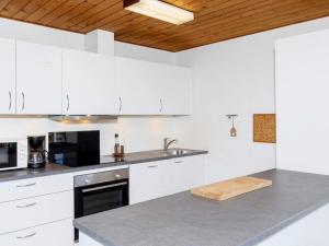 弗勒斯楚普7 person holiday home in Fr strup的厨房配有白色橱柜和木制天花板
