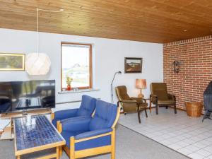 弗勒斯楚普7 person holiday home in Fr strup的客厅配有蓝色的沙发和椅子