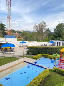 莫尼基拉Hotel Palmeras De Luz的公园内的大型游泳池,带游乐场