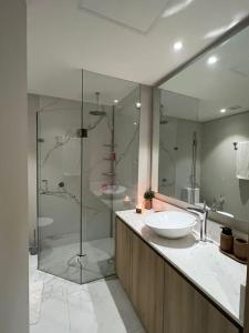 布塞里亚斯Marítima Golf Luxury Department 2BR的一间带两个水槽和玻璃淋浴间的浴室