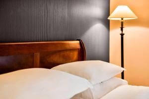 希灵登喜来登伦敦希思罗天际线酒店的一张带木头床头板和灯的床
