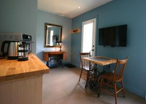 Saint AdrienGÎTE SUR L'ARC EN CIEL的厨房配有桌子,墙上设有电视
