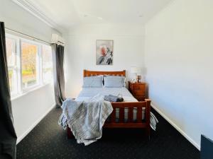 TalbingoTalbingo Lodge - Selwyn Accommodation的卧室配有一张床,卧室内有一个人躺在床上