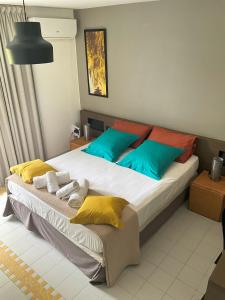 圣弗朗索瓦Good Mood Studio - Manganao Hôtel的一间卧室配有一张带色彩缤纷枕头的大床