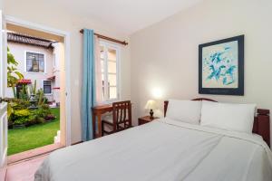 基多拉卡图加酒店的卧室设有一张白色大床和一扇窗户。