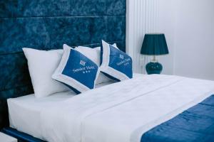 芹苴Senior Hotel的一张带蓝色和白色枕头的床