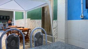 伦索伊斯Hospedaria Além das Trilhas的庭院配有带白色遮阳伞的桌子