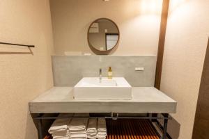 福冈Irodori Hotel DAIDAI的浴室设有白色水槽和镜子