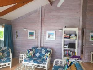 拉罗汤加沙滩别墅的一间设有两把椅子和书架的房间