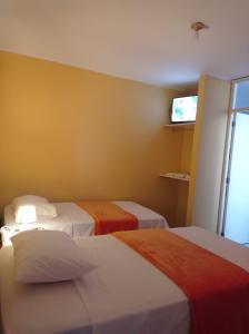 皮斯科Hostal Madrid的酒店客房设有两张床和电视。