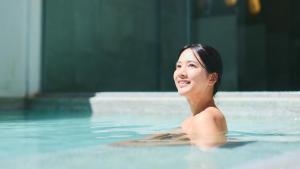 草津Fourtreat Kusatsu的女人在游泳池游泳