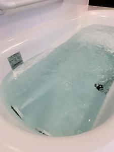 函馆元町全景公寓的浴室设有装满蓝色水的浴缸。