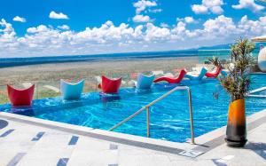 内罗毕Emara Ole-Sereni-Nairobi Park View的一个带红色和蓝色椅子的游泳池以及海滩