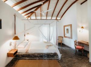 贝鲁沃勒Amuura Beach Villa的卧室配有白色的床和书桌
