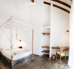 贝鲁沃勒Amuura Beach Villa的卧室配有白色的床和书桌