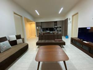 峇都丁宜海边@舒适海滨之家公寓的客厅配有两张沙发和一台电视机