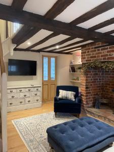 GodmanchesterHistoric Cambridgeshire Cottage的客厅配有蓝色的沙发和电视