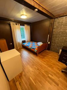 沃鲁Soo Rendimaja的一间卧室配有一张床,铺有木地板