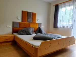 恩斯塔尔豪斯Apartment Steirawohnzimmer的一间卧室配有一张木床和木制床头板