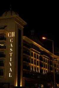 锡德Castival Hotel的一座建筑物,晚上在建筑物的一侧有标志