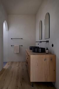 Brixenfink Restaurant & Suites的浴室设有木制水槽和两面镜子