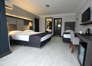 图兹拉Sahil Hotel Pendik的酒店客房设有两张床、一张桌子和一台电视。