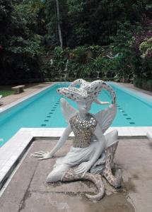 康提赫尔佳思富力安提酒店公寓的美人鱼雕像,坐在游泳池旁