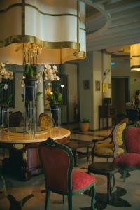 锡德Castival Hotel的一间房间,配有椅子和鲜花桌子