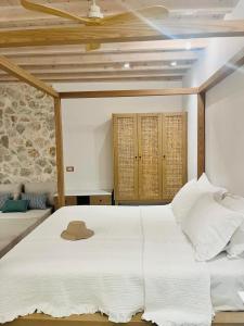 锡米Nisomar Suites的卧室配有白色的床和帽子