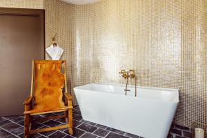 梅杰夫Grand Hotel Soleil d'Or的浴室设有白色浴缸,位于瓷砖墙壁上