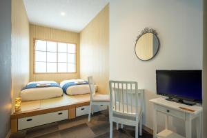 东松岛KIBOTCHA/キボッチャ的一间卧室配有一张桌子、一张床和一台电视