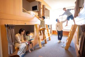 东松岛KIBOTCHA/キボッチャ的一组人在带双层床的房间里