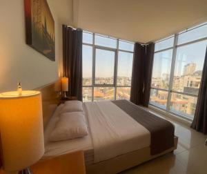 拉马拉Caesar Hotel Ramallah的一间卧室设有一张床和一个大窗户
