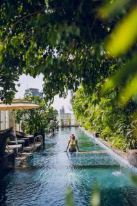 班加罗尔班加罗尔丽思卡尔顿酒店的度假胜地游泳池中的女人