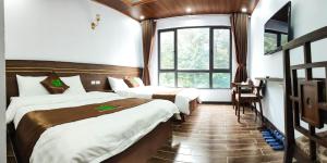 三岛县Rosalia Tam Đảo Hotel的酒店客房设有两张床和窗户。