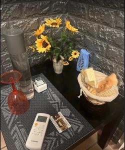 菲乌米奇诺Vegan Inn Airport - Adults Only - SELF CHECK IN的一张带遥控器的桌子和一个花瓶