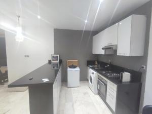 布兹尼盖roof top duplex with solarium的厨房配有白色橱柜和黑色台面