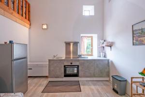 TornacMazet Tornac的厨房配有炉灶和冰箱。