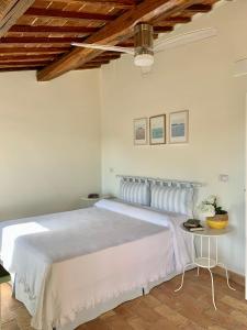 LubrianoCivita Secret Lodge的卧室配有一张白色大床和木制天花板