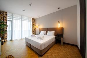 特拉布宗V Center Hotel的一间卧室设有一张大床和一个大窗户