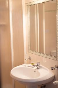 蓬特雷莫利Hotel Napoleon的浴室设有白色水槽和镜子