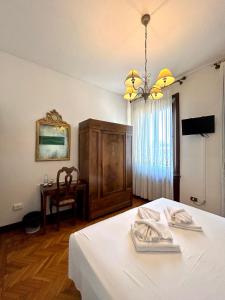 费拉拉迪莫拉800旅馆的一间卧室配有一张带桌子和吊灯的床。