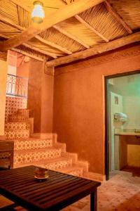 瓦尔扎扎特Ouednoujoum Ecolodge & Spa的一间带楼梯和桌子的房间,桌子上有四柱床